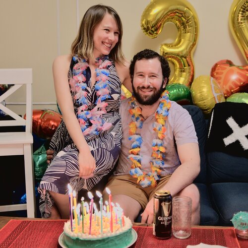 Nick and Julia in front of cake and balloons on his 30th birthday