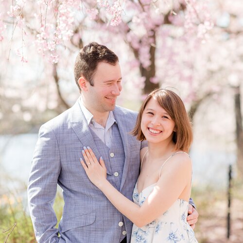 Julia and Nick smiling beneath cherry blossoms