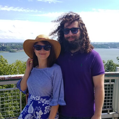 Nick and Julia smiling before a view of the
                      St. Lawrence River